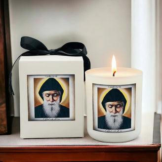 Candle with a printed portrait and a framed print on a shelf.